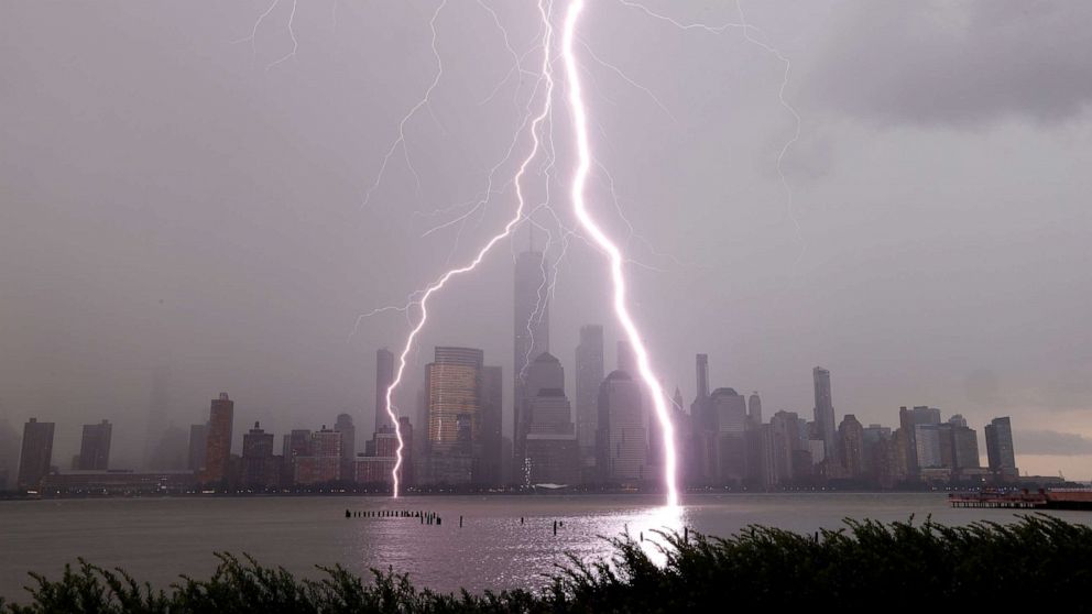 PHOTO: In this July 6, 2020, file photo, two lightning bolts frame One World Trade Center as they hit the Hudson River in New York during a thunderstorm.