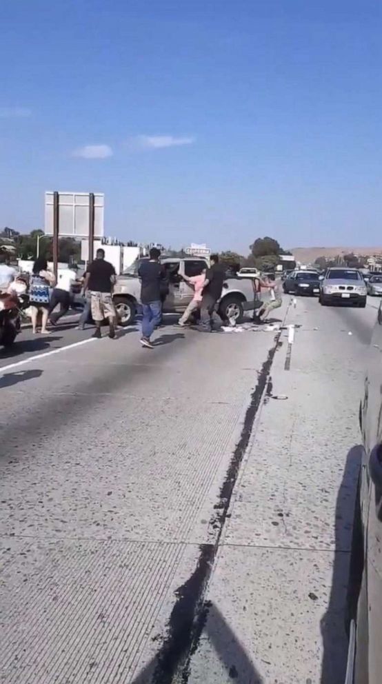 PHOTO: In a screen grab from a video posted to Jorge Tiznado's twitter account, Jorge's father and other people help rescue a driver from a flipped over pickup truck.