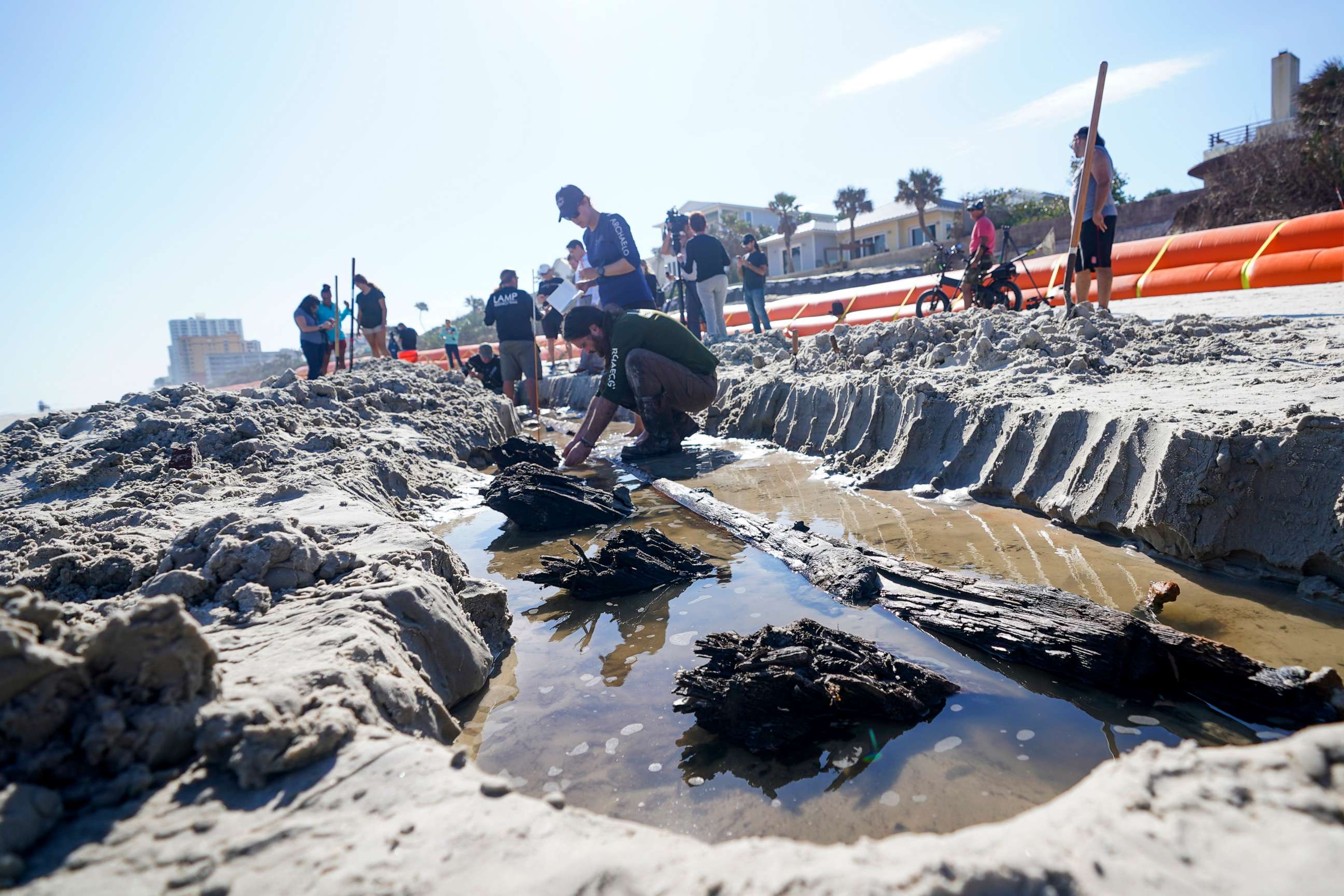 PHOTO: Members of a team of archaeologists study a wooden shipwreck in the sand, Dec. 6, 2022, in Daytona Beach, Fla.