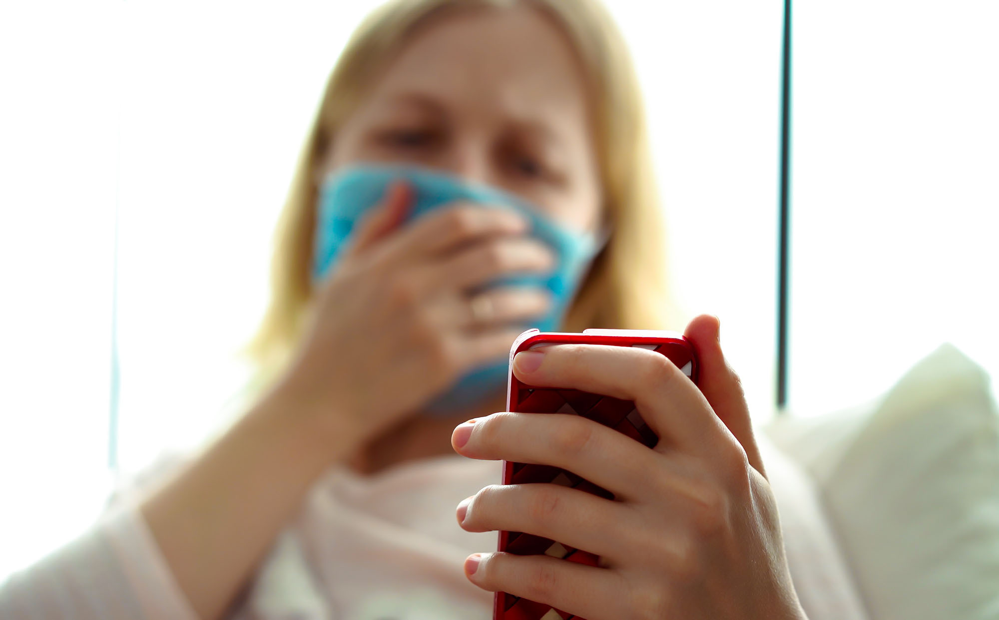 PHOTO: A sick woman holds a smartphone in an undated stock image.