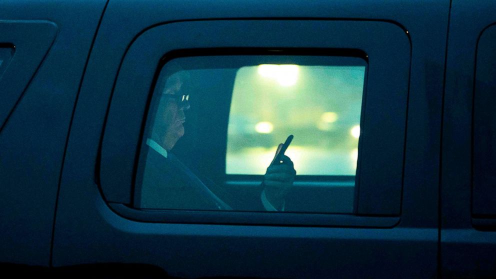 PHOTO: President Donald Trump, with reading glasses, looks at his cellphone as he departs the White House for a campaign trip to Milwaukee, Jan. 14, 2020. 