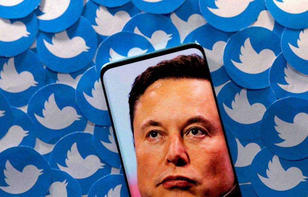 PHOTO: An image of Elon Musk is seen on a smartphone placed on printed Twitter logos in this picture illustration taken April 28, 2022.