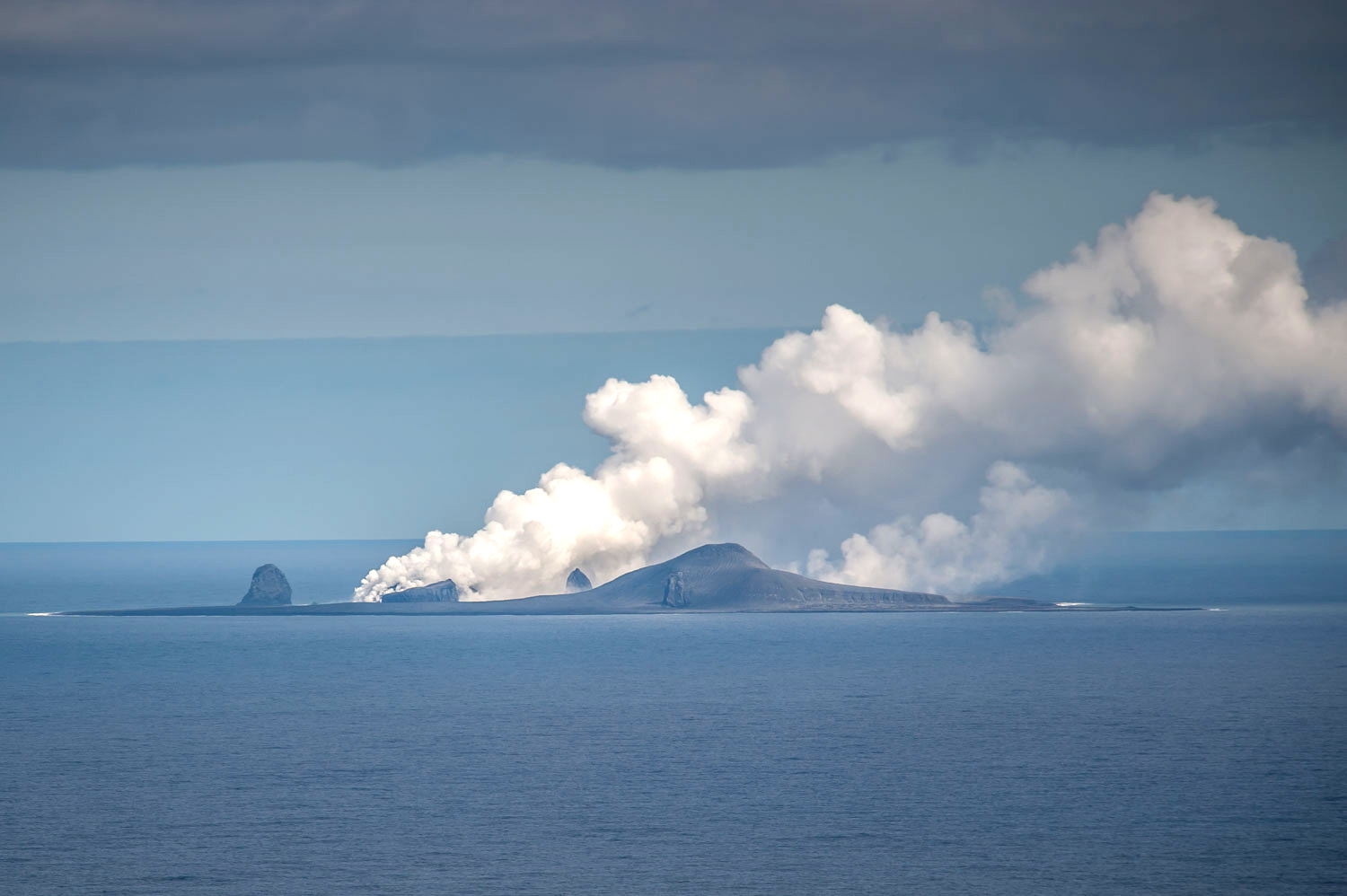 PHOTO: A plume of steam flows upward from Bogoslof volcano, a partially submerged volcano that created giant underwater bubbles when it erupted in 2017.