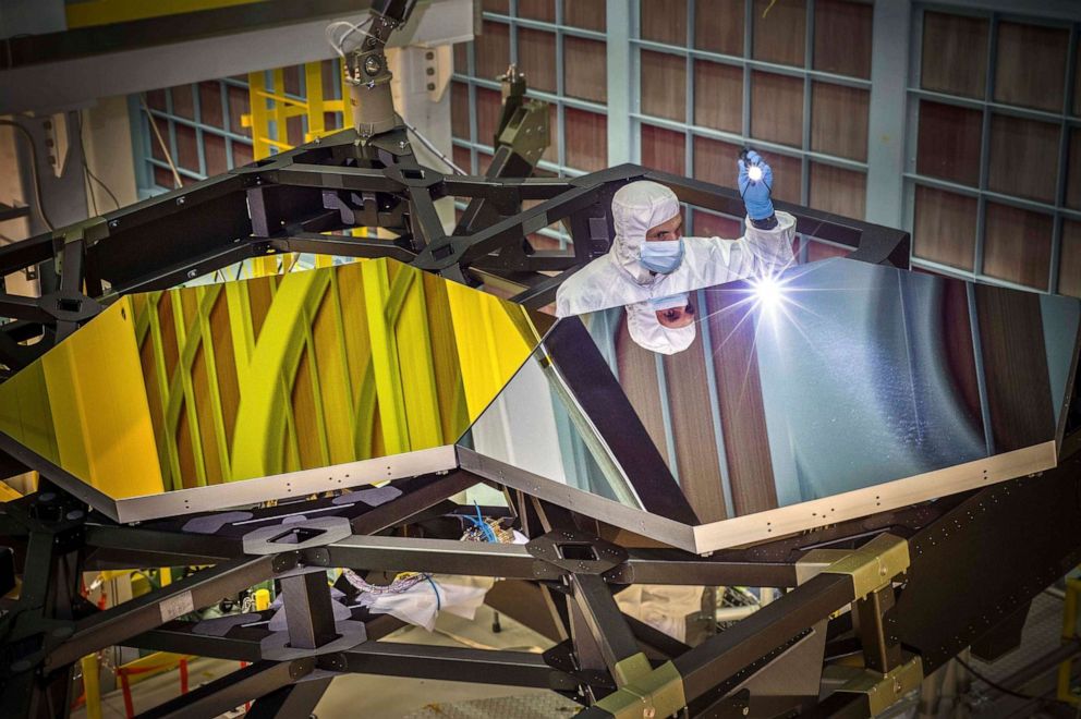 PHOTO: James Webb Space Telescope Optical Engineer Larkin Carey examines two test mirror segments on a prototype at the Goddard Space Flight Center's giant clean room in Greenbelt, Md.