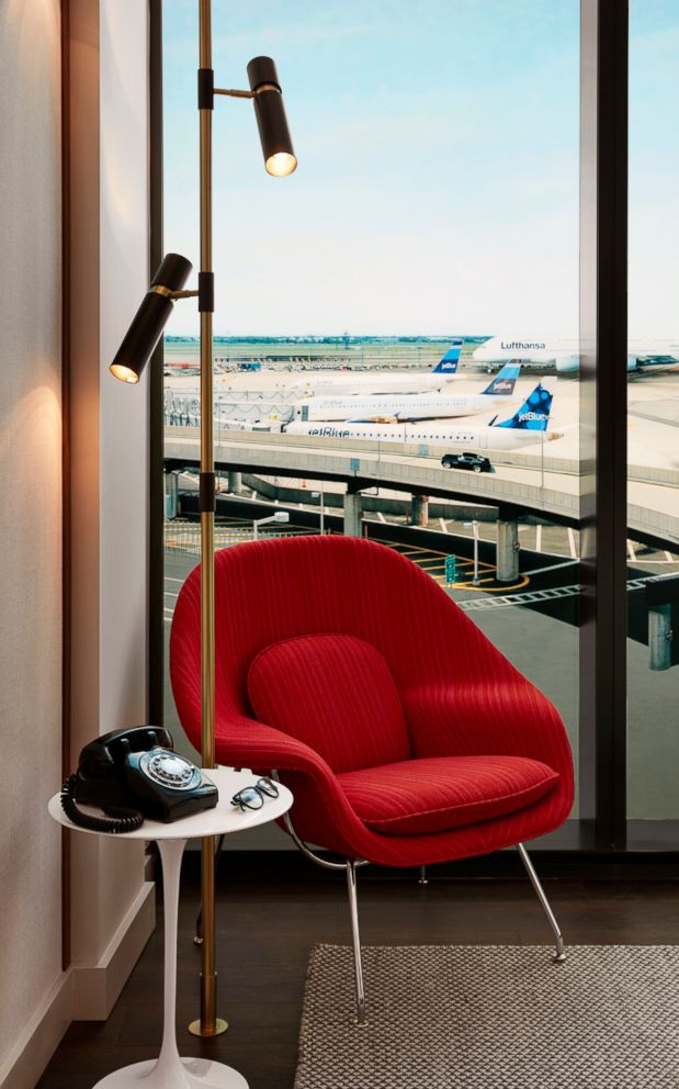 An authentic Eero Saarinen-designed Womb Chair sits beside a round white Saarinen Pedestal tulip side table where guests can make unlimited free international and local calls on a 1950's Western Electric 500 phone retrofitted converter by Old Phone Works.