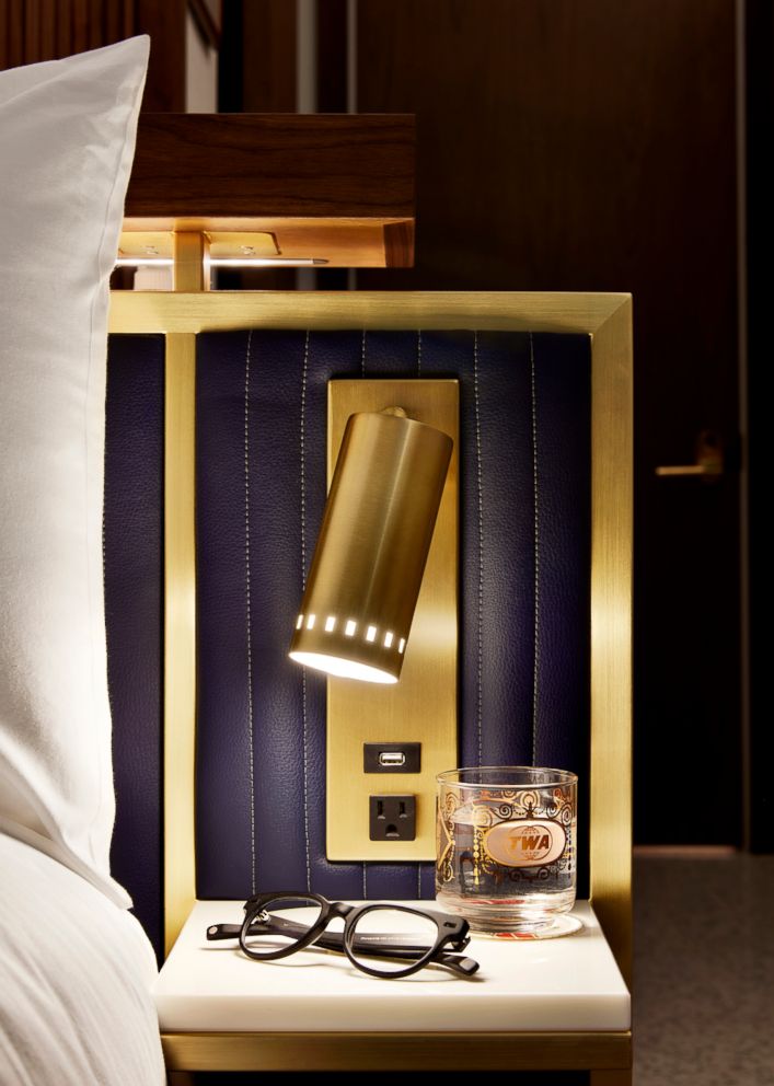 PHOTO: Lined in brass, a custom quilted leather-look headboard features a custom brass sconce and a crystallized glass ledge that easily holds overnight accessories.