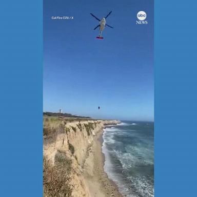 VIDEO: Kite surfer stranded on beach uses rocks to spell out 'HELP' in the sand