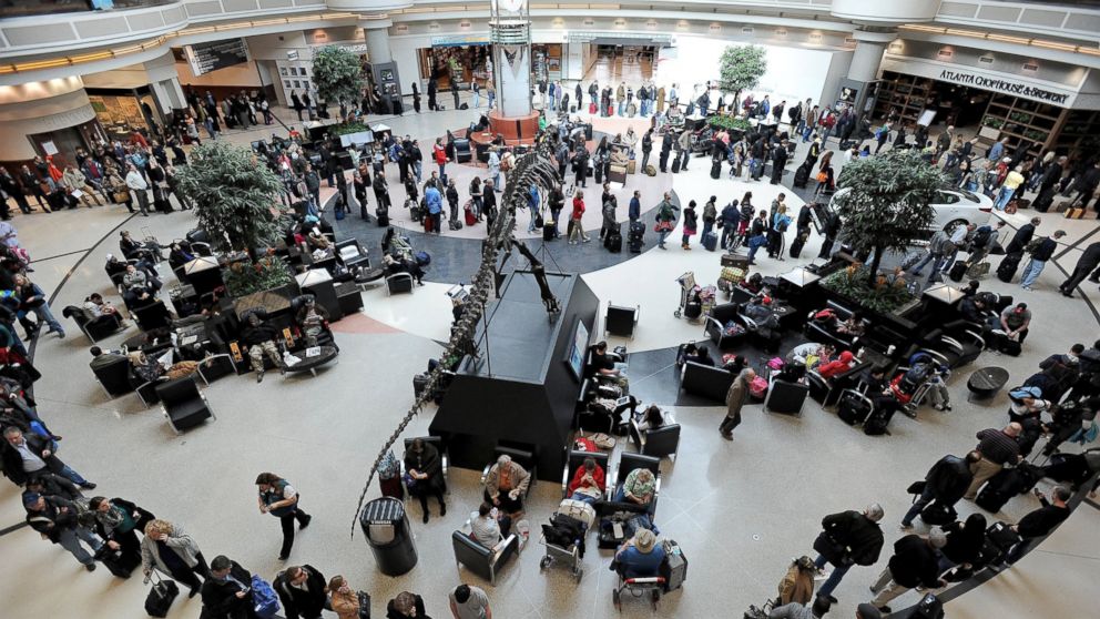 A long line of travelers winds around the atrium at Hartsfield-Jackson International Airport, Feb. 13, 2014, in Atlanta.