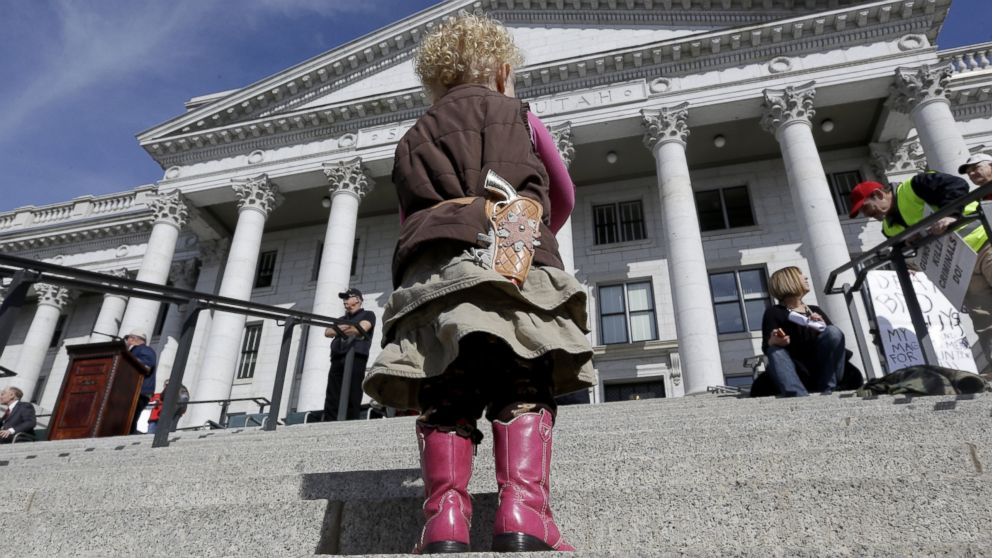 Arinna Ludlum, 2, carries her toy six-shooter gun during a rally for the 2nd Amendment at the Utah State Capitol, March 2, 2013, in Salt Lake City.