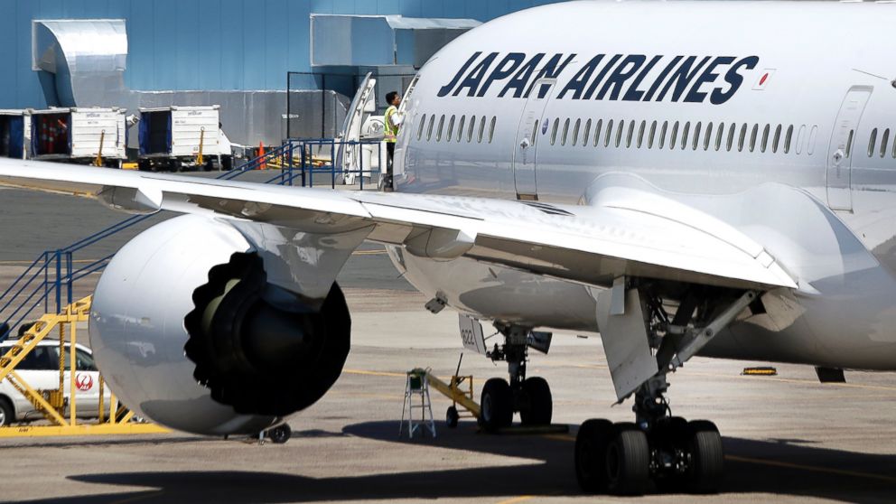 An airport worker enters a Japan Airlines Boeing 787 aircraft as it sits on the tarmac at Terminal E at Logan International Airport in Boston, July 19, 2013.