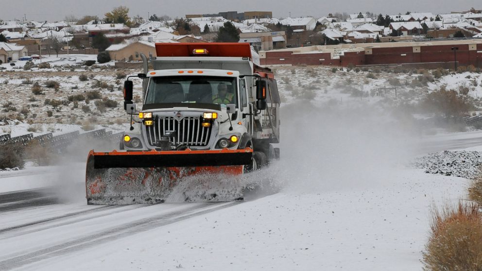 A plow and sanding truck clears a road after a winter storm hit New Mexico, making driving difficult in Albuquerque, N.M., Nov.24, 2013.