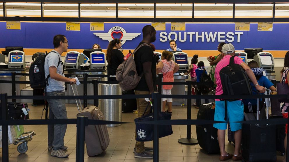 Travelers wait to check bags with Southwest Airlines Co. ticket counters in Terminal 1 of Los Angeles International Airport (LAX) in Los Angeles on Aug. 18, 2015. 