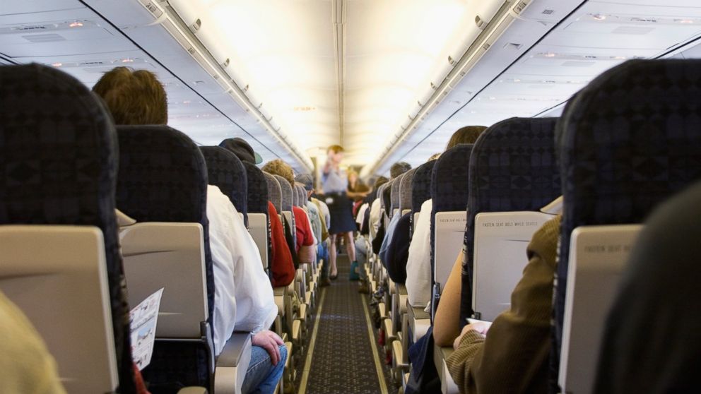 Passengers sit in a full airplane.