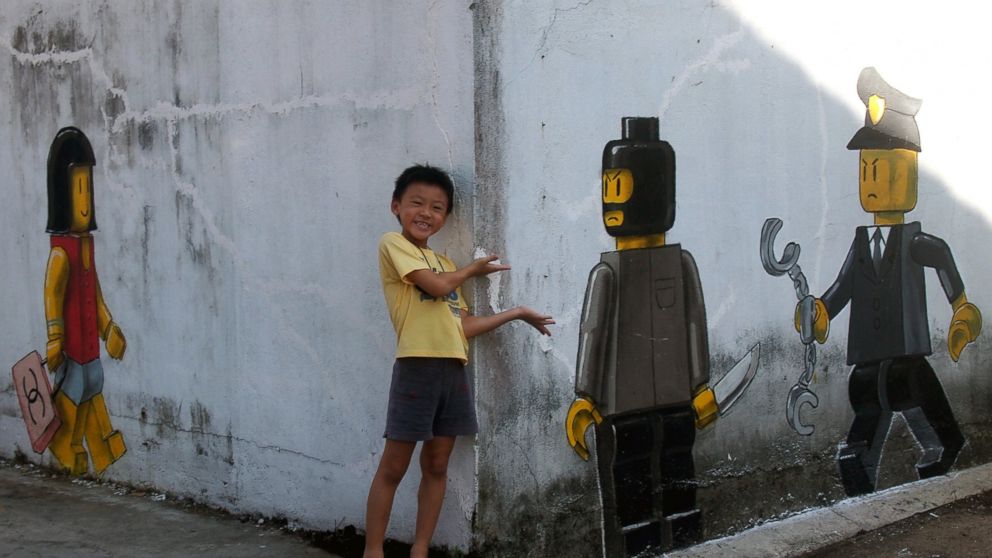 PHOTO: Lithuanian artist Ernest Zacharevic's controversial mural depicts a Lego woman with a Chanel bag , a Lego robber with a knife on a wall in Johor Bahru, Malaysia. 