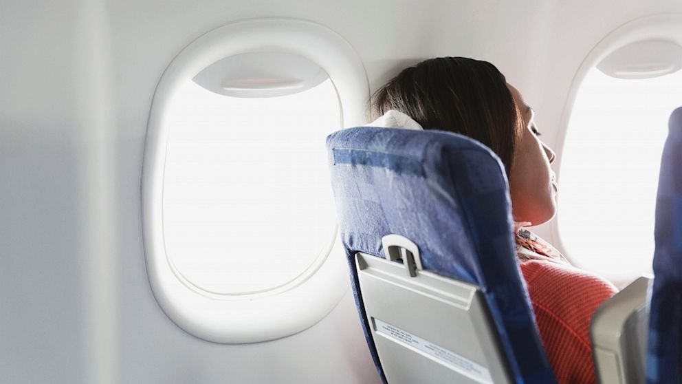 A woman sleeps in an airplane.
