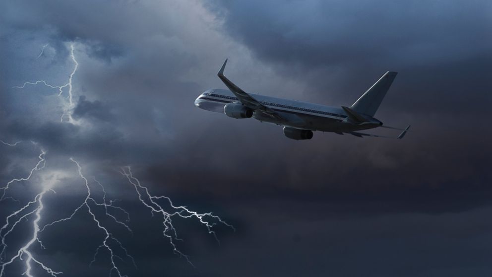 A plane is pictured flying during a lightning storm in this stock image.