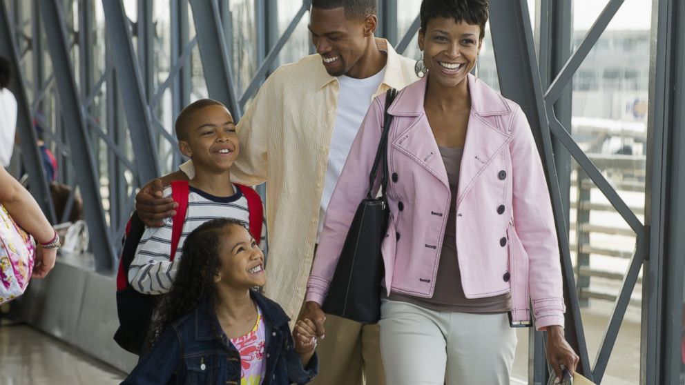 A family is pictured walking in an airport in this stock image. 