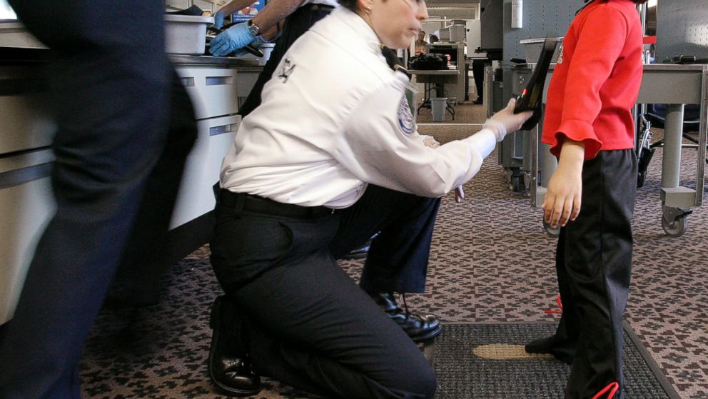 A TSA agent performs a pat-down check on a young girl at a security checkpoint at Phoenix Sky Harbor International Airport, December 2004, in Phoenix.