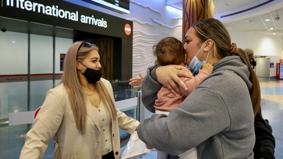 Families embrace after a flight from Los Angeles arrived at Auckland International Airport as New Zealand's border opened for visa-waiver countries Monday, May 2, 2022. New Zealand welcomed tourists from the U.S., Canada, Britain, Japan and more than