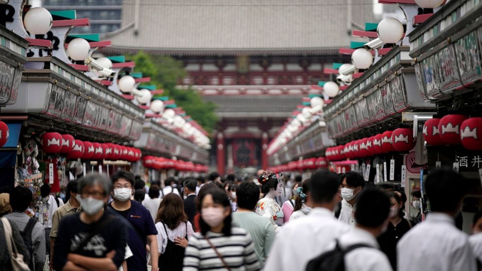 Visitors walk along a shopping street at the Asakusa district Friday, June 10, 2022, in Tokyo. Japan on Friday eased its borders for foreign tourists and began accepting applications, but only for those on guided package tours who are willing to foll