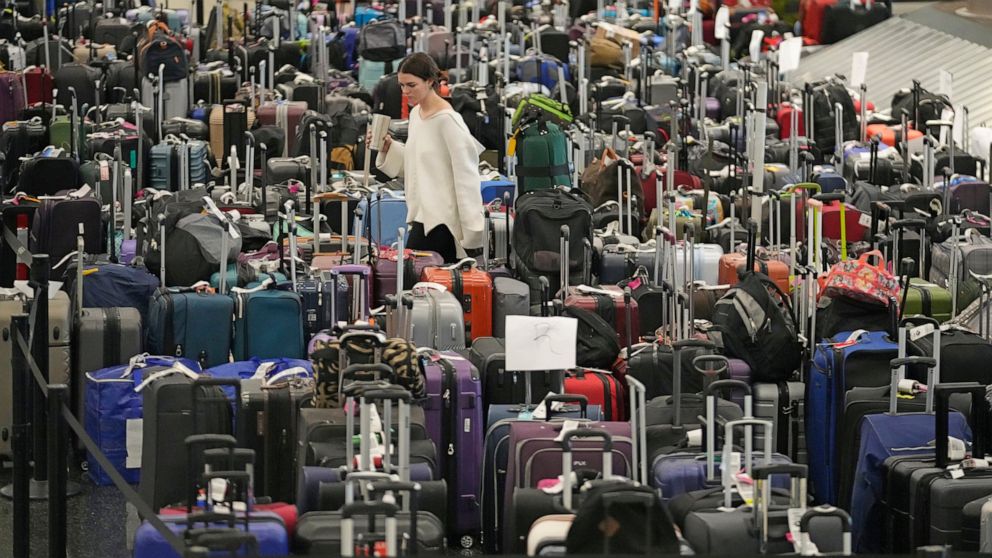 A woman walks through unclaimed bags at Southwest Airlines baggage claim at Salt Lake City International Airport Thursday, Dec. 29, 2022, in Salt Lake City. Southwest Airlines is still trying to extract itself from sustained scheduling chaos and canc
