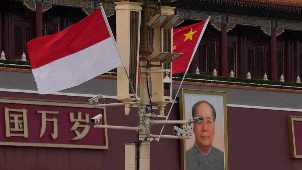 The Indonesian and Chinese national flags are flown together near Mao Zedong's portrait on Tiananmen Gate in Beijing, Monday, July 25, 2022. Indonesian President Joko Widodo was heading to Beijing on Monday for a rare visit by a foreign leader under 