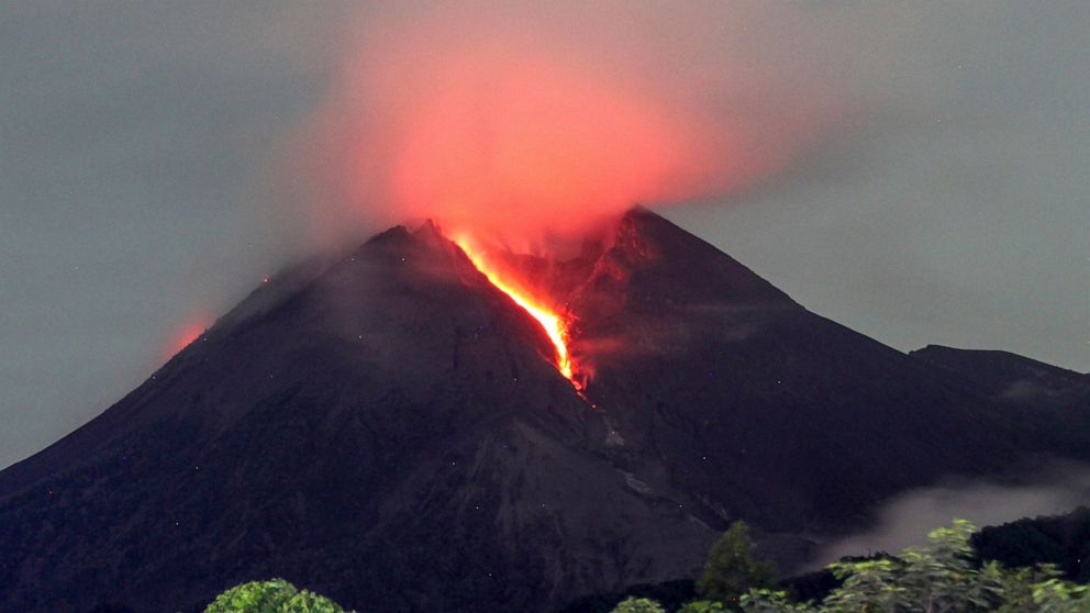 Lava flows down from the crater of Mount Merapi seen from Cangkringan village in Sleman, Yogyakarta, early Friday, March 11, 2022. Indonesia's Mount Merapi continued eruption Friday, forcing authorities to halt tourism and mining activities on its sl