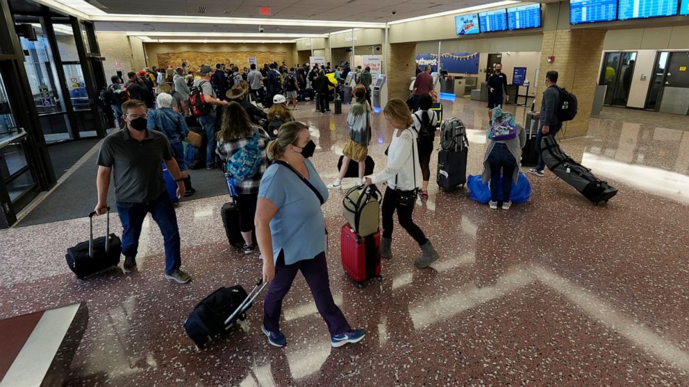 Passengers queue up at the ticketing counter for Southwest Airlines Sunday, Oct. 10, 2021, in Eppley Airfield in Omaha, Neb. Southwest Airlines canceled hundreds of flights over the weekend, blaming the woes on air traffic control issues and weather.