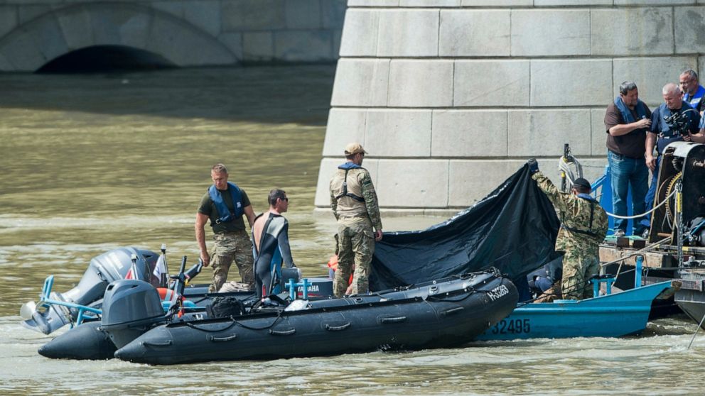 A corpse freed from the shipwreck is covered with a black sheet at Margaret Bridge in Budapest, Hungary, Tuesday, June 4, 2019. A sightseeing boat carrying 33 South Korean tourists was crashed by a large river cruise ship and sank in the River Danube