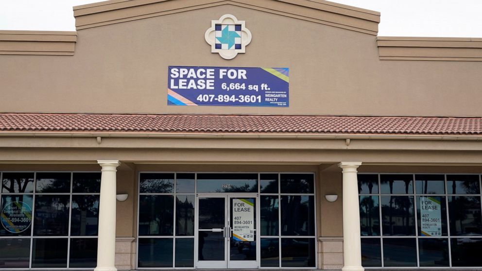 Signs advertise a business space for lease at a shopping plaza, Tuesday, Jan. 12, 2021, in Orlando, Fla. The distribution of COVID-19 vaccines is fueling optimism that Americans will increasingly return to the ways they used to shop, travel and work 