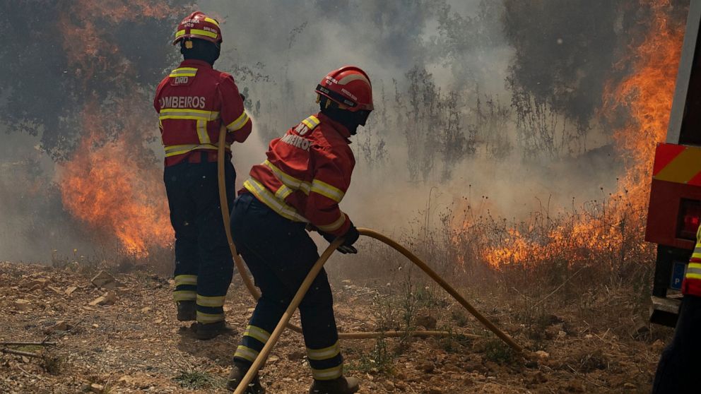 Firefighters try to extinguish a wildfire near Colos village, in central Portugal on Monday, July 22, 2019. More than 1,000 firefighters battled Monday in torrid weather against a major wildfire in Portugal, where every summer forest blazes wreak des