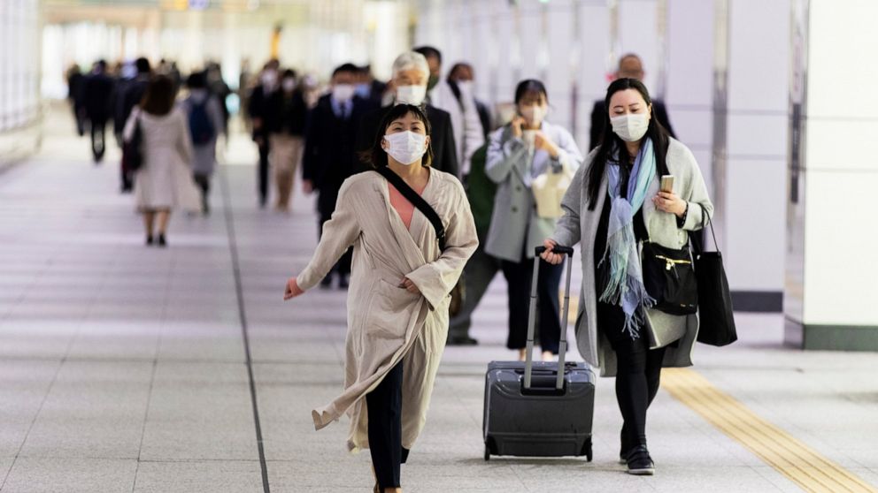 People wearing face masks to help curb the spread of the coronavirus walk towards a train station in Tokyo on Friday, April 23, 2021. (AP Photo/Hiro Komae)