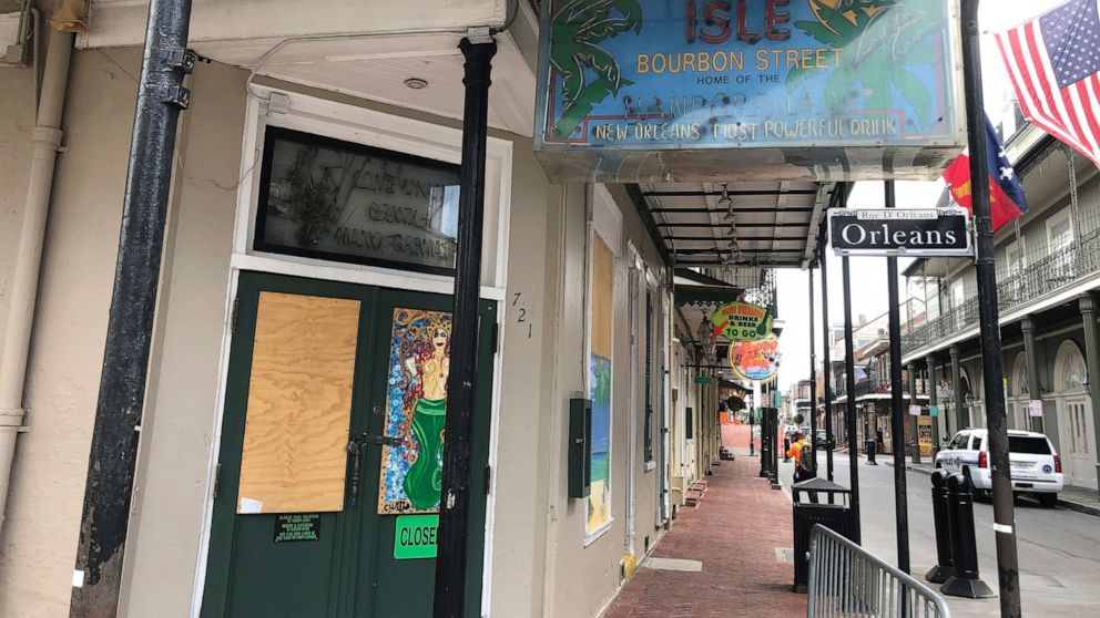 In this Wednesday, May 20, 2020, a bar is boarded-up at a Bourbon Street intersection in New Orleans’ French Quarter. Bars have been closed in New Orleans since early March because of the coronavirus pandemic. Some residents of the historic French Qu