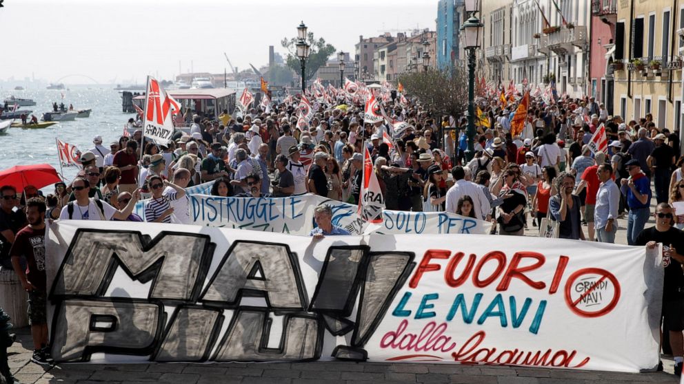People march during a demonstration against cruise ships being allowed in the lagoon, in Venice, Italy, Saturday, June 8, 2019. Venice environmentalists have long complained that cruise ships displace water, wear down fragile foundations, cause air p