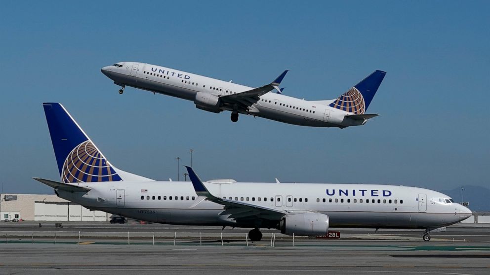 FILE - In this Oct. 15, 2020, file photo, a United Airlines airplane takes off over a plane on the runway at San Francisco International Airport in San Francisco. United Airlines warns that bookings are slowing down and cancellations are on the rise 