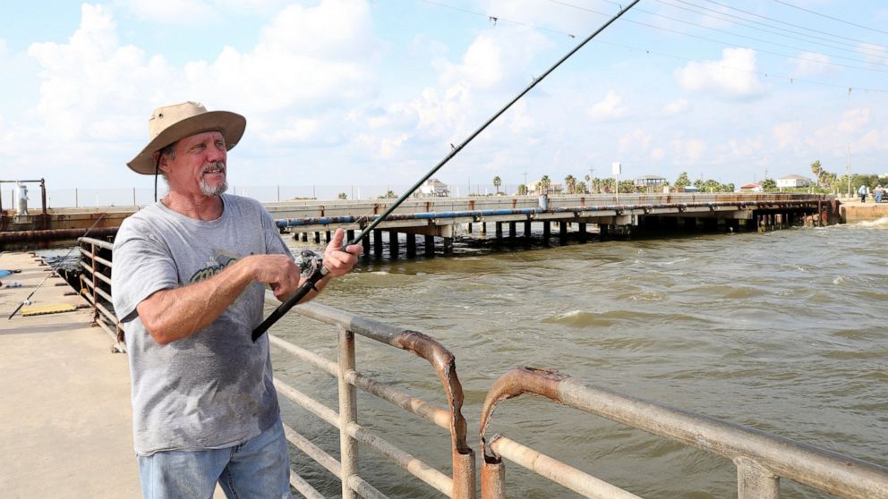 In this Monday, Sept. 9, 2019 photo, a Gerald Cross sets a line in the channel at Rollover Pass on the Bolivar Peninsula near Galveston, Texas. Cross, who has been fishing at Rollover Pass since he was 10-years old, voiced his objections about fillin
