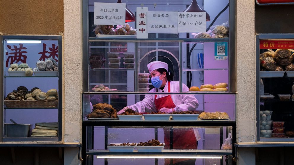 In this photo taken Saturday, Feb. 22, 2020, a chef works near display of food products at a restaurant in Beijing. Small, mostly private companies that are the engine of China's economy are back to operating at one-third of normal levels after anti-