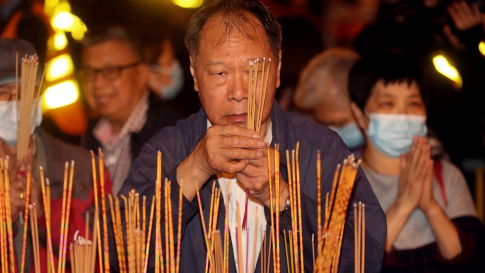 A man burn joss sticks as he prays at the Wong Tai Sin Temple, Friday, Jan. 24, 2020, in Hong Kong, to celebrate the Lunar New Year which marks the Year of the Rat in the Chinese zodiac. China is expanding its lockdown against the deadly new virus to