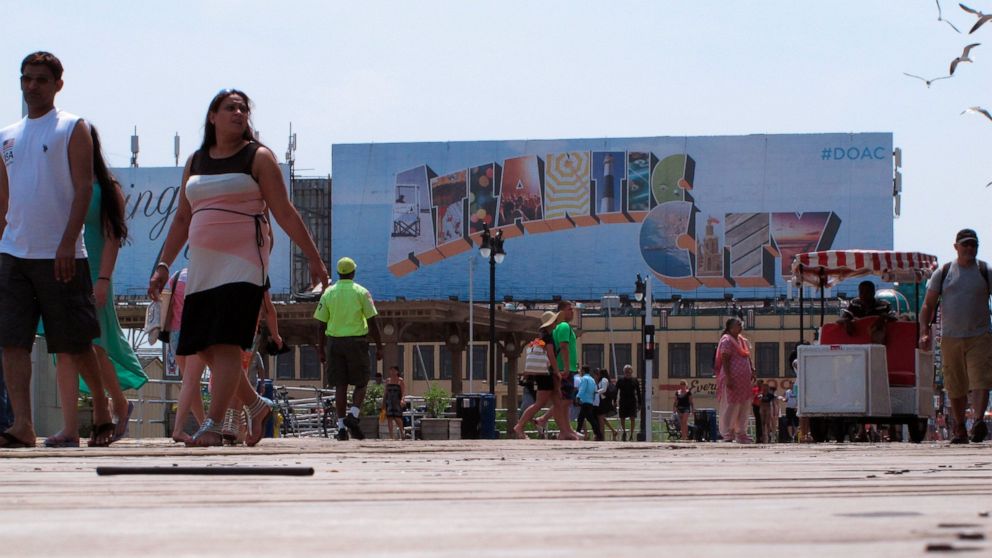 This July 3, 2015 photo shows people walking on the Boardwalk in Atlantic City N.J. Top executives of most of Atlantic City's casinos on Thursday, Jan. 30, 2020, say the city needs to become cleaner and safer, with a better public perception in order