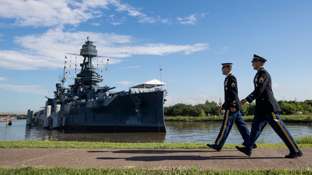 FILE - In this June 6, 2019 file photo, Army Staff Sgt. Jacob Klein, left, and Staff Sgt. Joel Ocasio walk past Battleship Texas to participate in a ceremony commemorating the 75th anniversary of D-Day, in La Porte, Texas. Public visits to the 107-ye