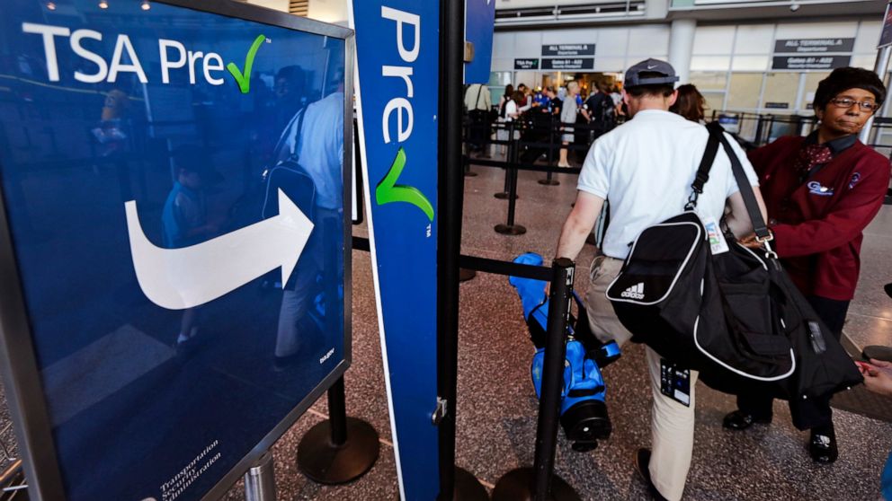 FILE - A passenger passes by a sign for the Transportation Security Administration's TSA PreCheck line in Terminal A at Logan Airport in Boston, Monday, June 27, 2016. Air travelers are finally getting a break on fares. The government said Wednesday,