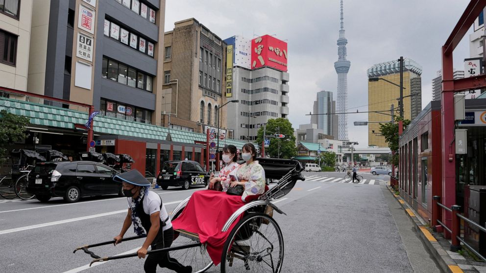 A rickshaw puller carries his customers around Tokyo's Asakusa area famous for sightseeing, Wednesday, June 22, 2022. Japan is bracing for a return of tourists from abroad, as border controls to curb the spread of coronavirus infections are gradually