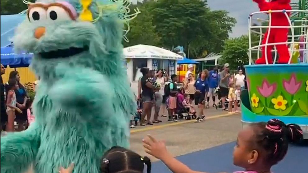 In this image from video provided by Jodi Brown, posted to Instagram on Saturday, July 16, 2022, a performer dressed as the character Rosita waves off Brown's daughter and another 6-year-old Black girl at the Sesame Place amusement park in Langhorne,