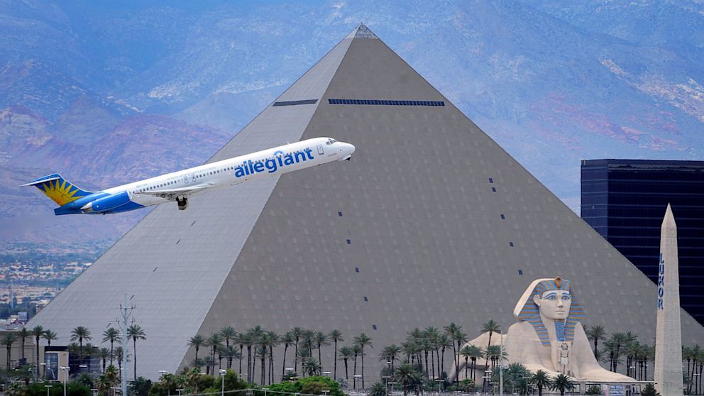PHOTO: In this May 9, 2013, photo, an Allegiant Air jetliner flies by the Luxor Resort & Casino after taking off from McCarran International Airport in Las Vegas.  Allegiant Air has been profitable for 10 straight years.