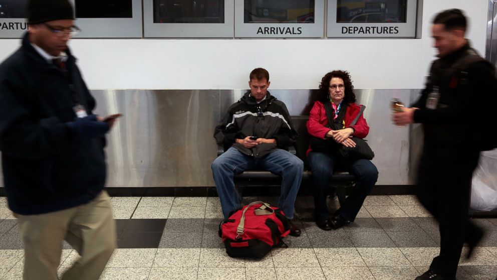 Two travelers wait in the ticketing area of B terminal at La Guardia Airport in New York, Jan. 17, 2014.