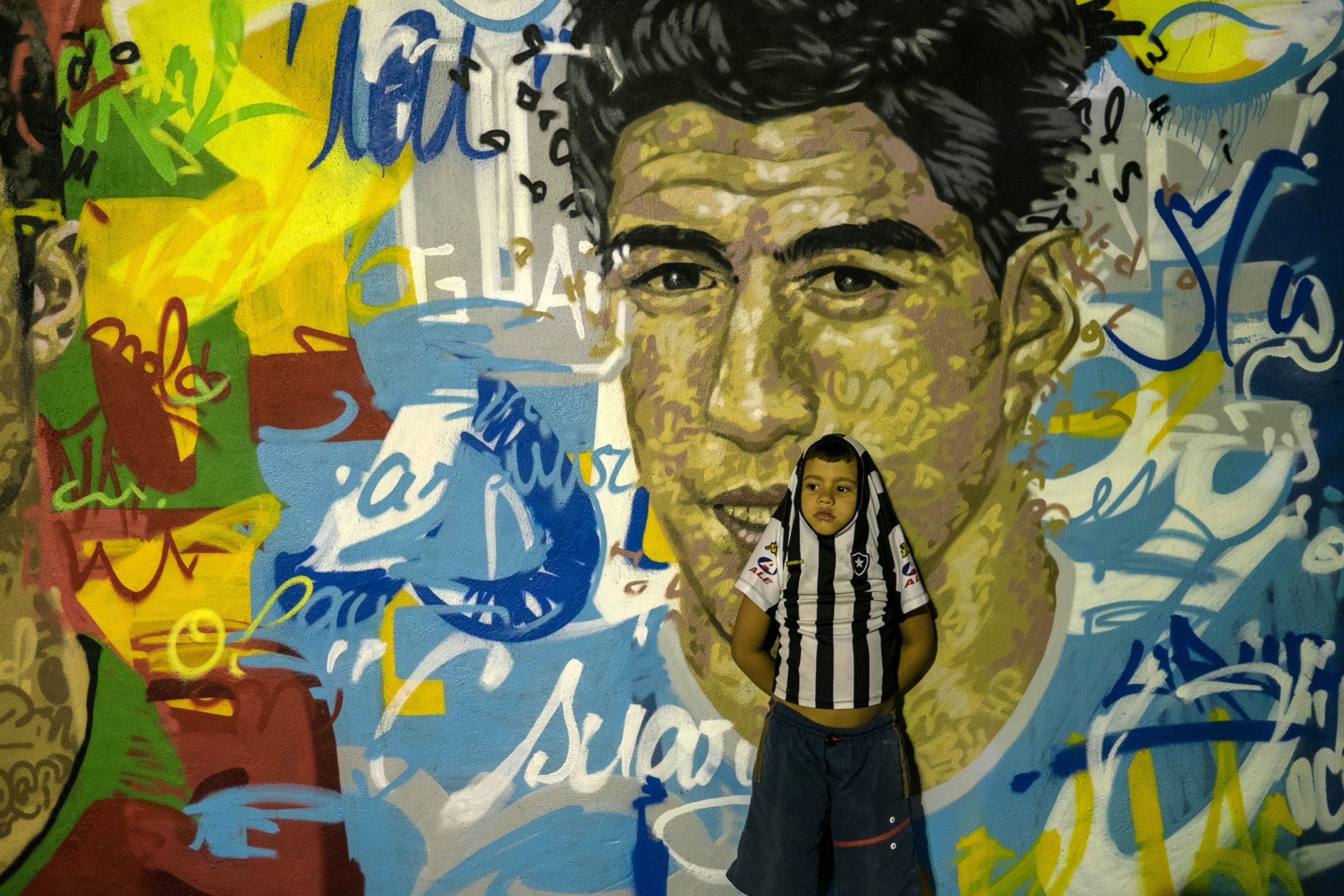 PHOTO: A boy leans on a mural with the portraits of famous football players at Tavares Bastos favela in Rio de Janeiro, Brazil, on May 21, 2014.