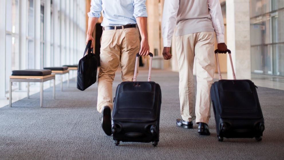 Businessmen roll luggage in hallway in this undated stock image.
