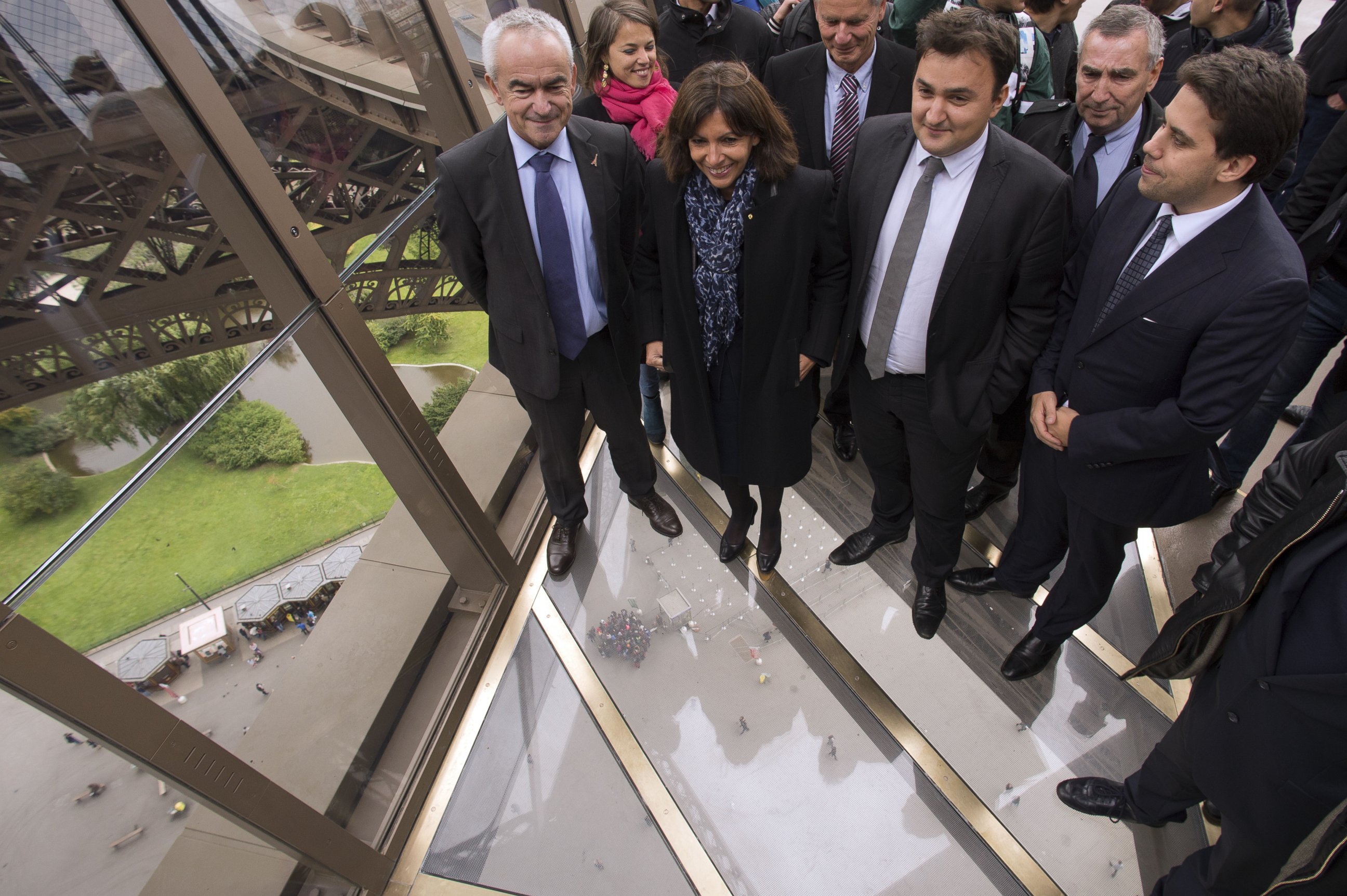 PHOTO: Paris' mayor Anne Hidalgo (C) walks on the new glass floor at the Eiffel Tower during its inauguration in Paris on Oct. 6, 2014. 
