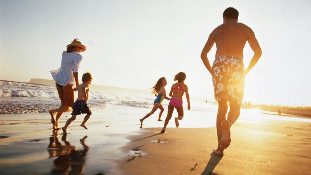 A family runs on the beach at sunset in this undated stock photo. 