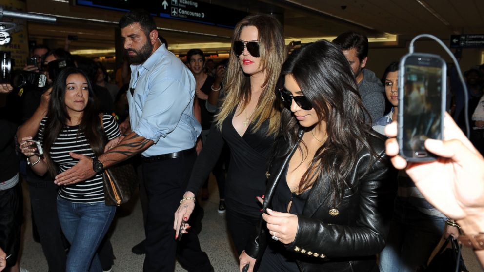 Khloe Kardashian and Kim Kardashian are surrounded by fans at the airport in Miami, Fla. on March 11, 2014.